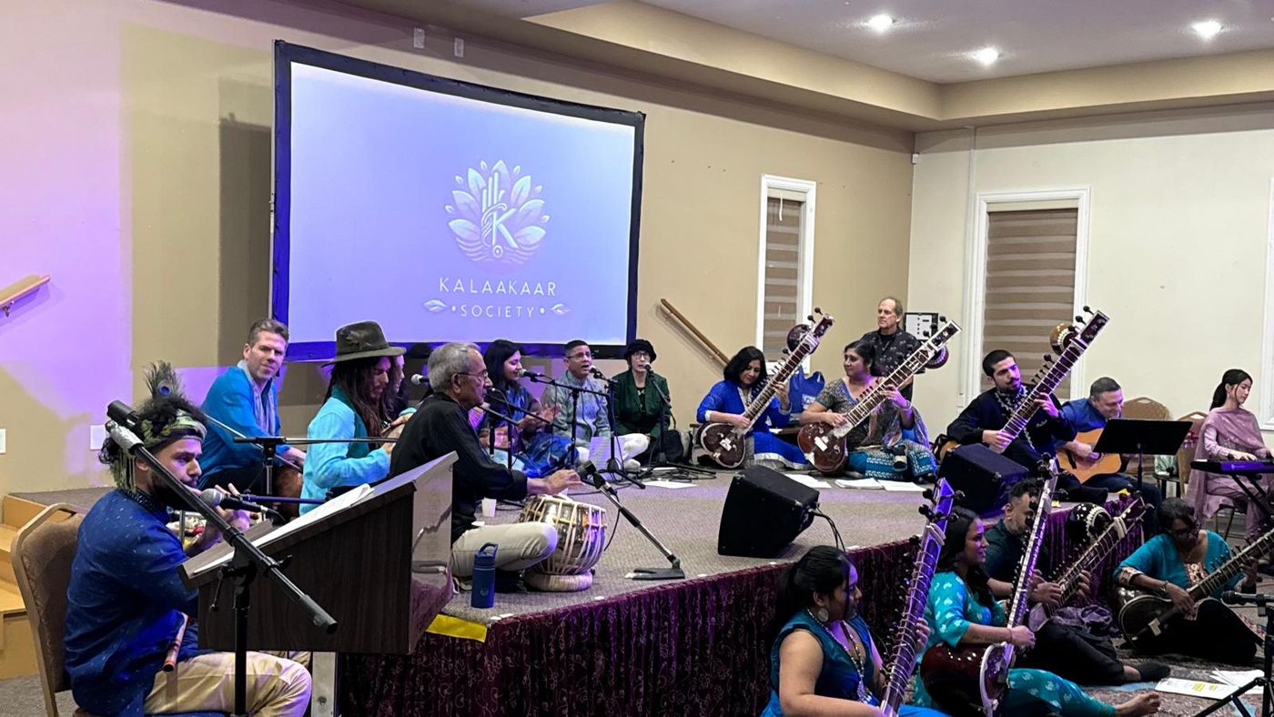 An ensemble with various instruments performing together for a seated audience